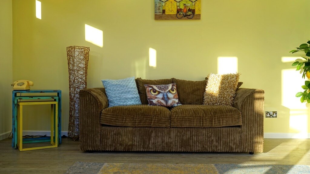 Желтый фон для коричневого дивана